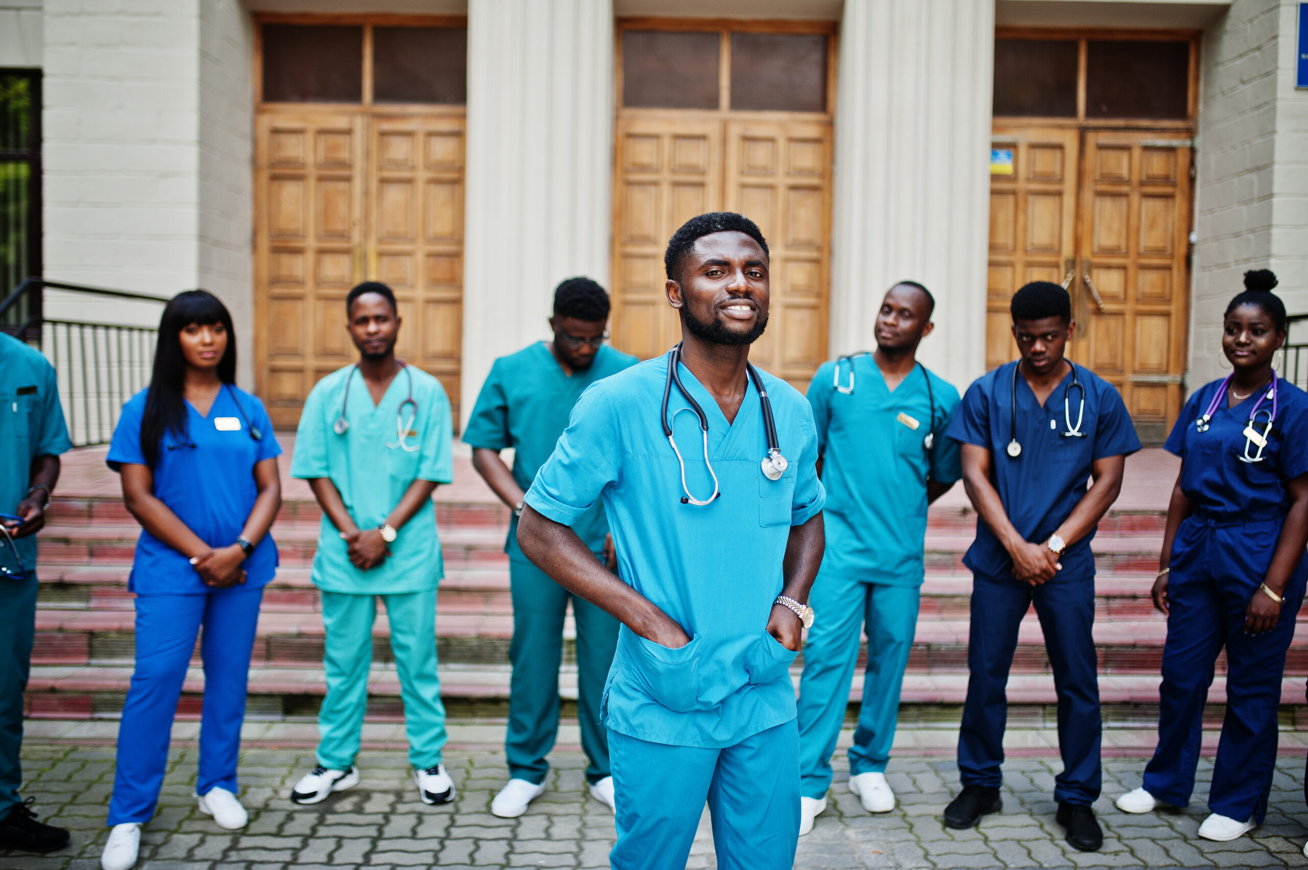 Group of african medical students posed outdoor against university door.