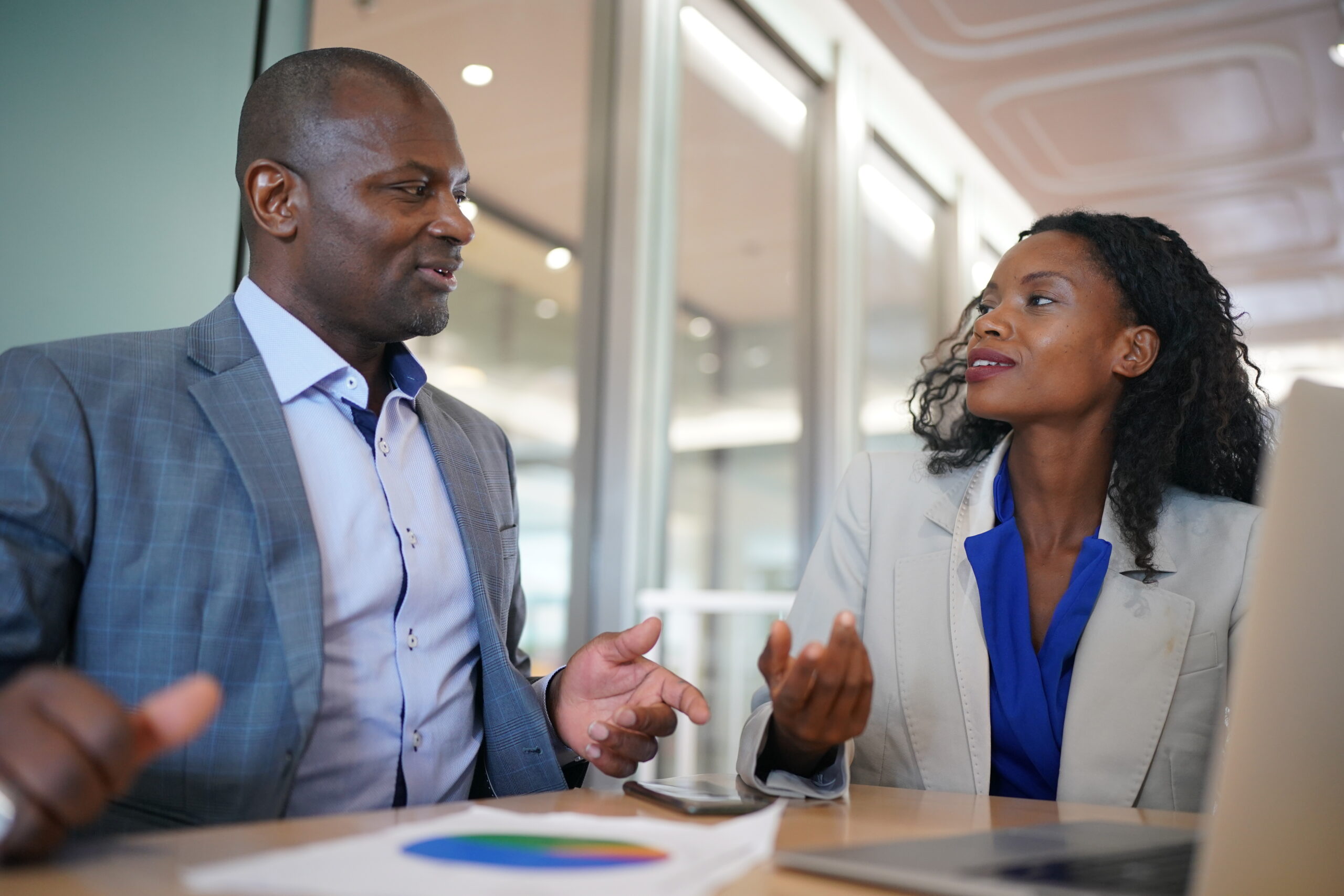 Young man consulting his business partner at meeting in office